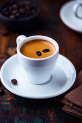 Cup of espresso crema with coffee beans