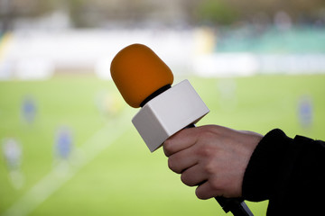 hand hold microphone for  interview during a football mach