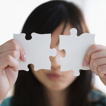 Korean woman holding two puzzle pieces
