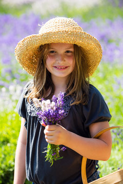 Cute young girl in a field of purple lavender