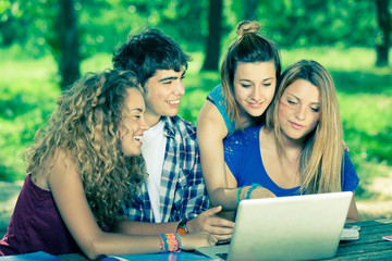 Group of Teenage Students at Park with Computer and Books