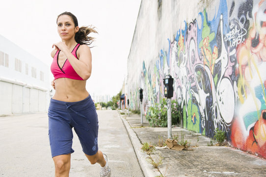 Hispanic woman running in urban area