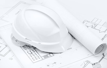 White hard hat on working or engineering drawings