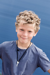 Portrait of the curly boy with a key on a neck