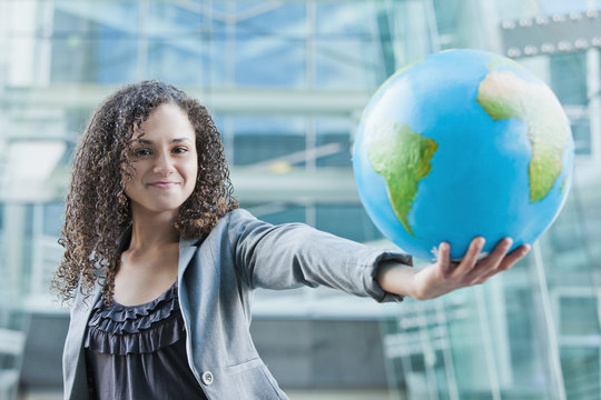 Caucasian businesswoman holding globe