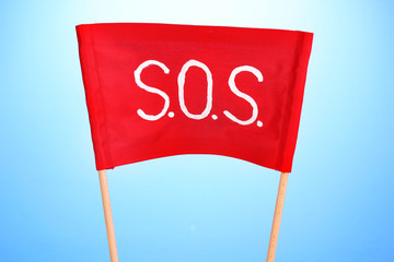 SOS signal written on red cloth on blue background