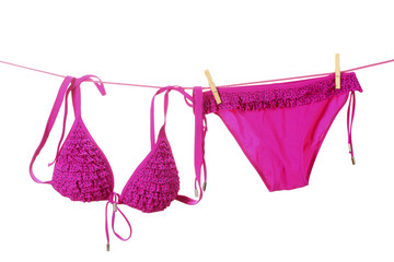 Women's swimsuit hanging on a rope on white background