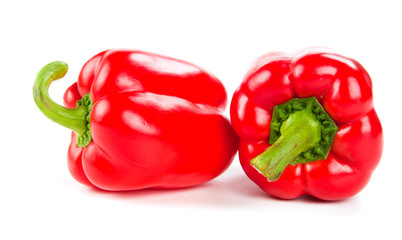 two fresh red peppers on white