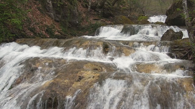 Rapid mountain river, with small waterfalls.
