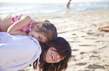 Mamma gioca sulla spiaggia con la figlia