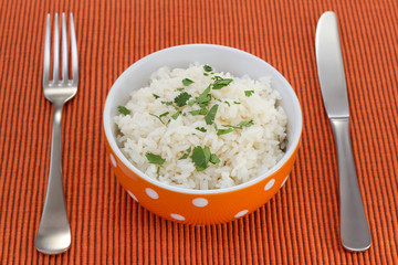 boiled rice in orange bowl with parsley