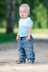Fototapeta premium Happy little boy in the green park