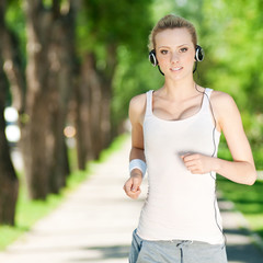 Young woman running in green park