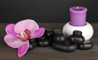 Fototapeta na wymiar Kamienie spa z kwiat orchidei i świeca