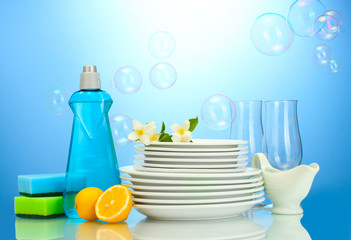 empty clean plates and glasses with dishwashing liquid, sponges