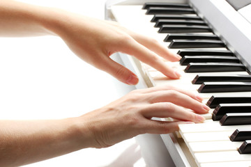 hands of woman playing synthesizer