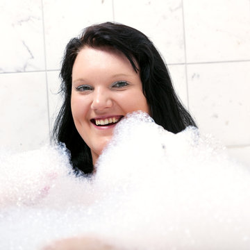 Young woman has fun in the bathtub