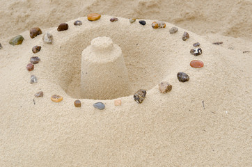 Fototapeta na wymiar zamek z piasku ozdobiony kamykami