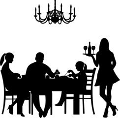 Silhouette of a restaurant  were a family enjoy their dinner