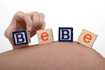 Pregnant woman with building blocks resting on belly