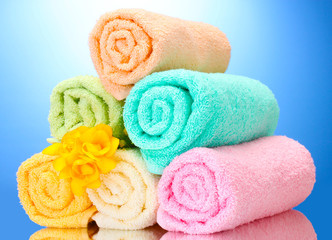 Obraz na płótnie Canvas colorful towels and flowers on blue background