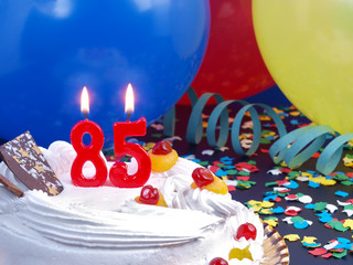 Birthday cake with red candles showing Nr. 85