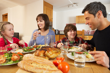 Obraz na płótnie Canvas Rodzina jedząc obiad Razem W Kuchni