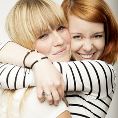 red and blond haired girls laughing and hug