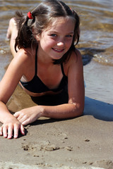 Little girl playing on sand beach