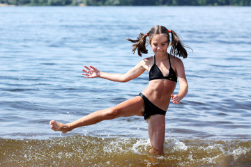 Little girl playing on sand beach