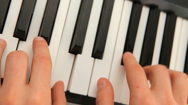 Fingers touching piano keys