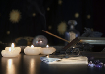 Esoterik allgemein - Tarotkarten, Räucherstäbchen und Kerzen vor Astrologiehintergrund