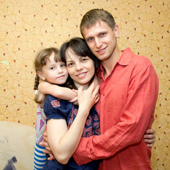 Fototapeta premium Father, mother and daughter hugging and smiling