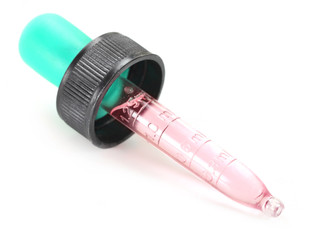 Dropper with pink syrup over white background