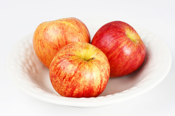 Three apples in white bowl