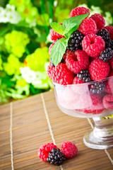 Sweet fresh fruits in glass goblet with mint leaf