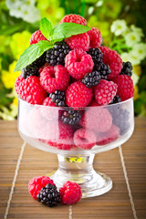 Sweet fresh fruits in glass goblet with mint leaf