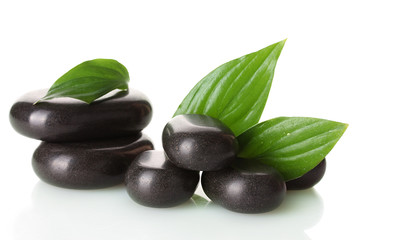 Spa stones and green leaves isolated on white