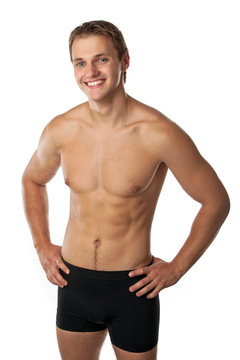 Cheerful young man in trunks over white background