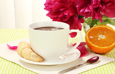 cup hot chocolate, cookies and flowers on table in cafe