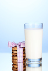 Glass of milk and cookies on blue background