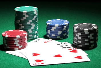 Cards and chips for poker on green table