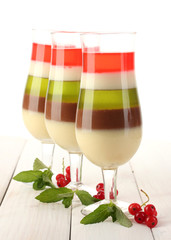 fruit jelly in glasses, redcurrants and mint on wooden table