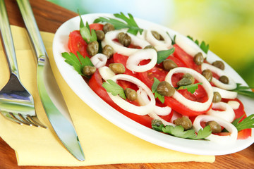 Salad with capers in the plate on bright green background