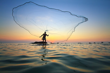 throwing fishing net during sunrise