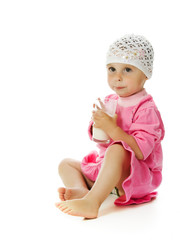 pretty little girl is holding a glass of milk