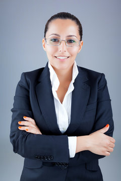 Portrait of beautiful business woman wearing glasses against gre
