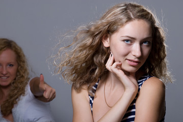 Two blondes on a gray background