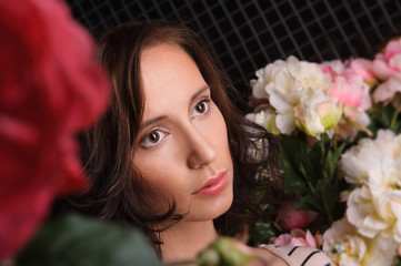 Portrait of young gorgeous woman with flowers at dark room with