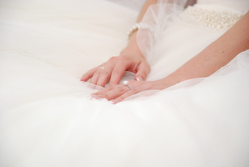 Hands of bride on a wedding white dress